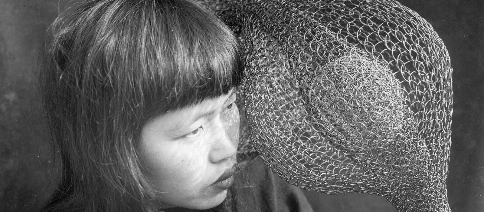 Ruth Asawa's face next to one of her sculptures