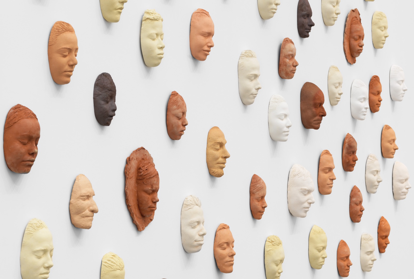 clay faces on a wall